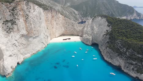 Stunning-aerial-view-of-Navagio-beach-with-white-sand,-clear-crystal-water-and-sunny-blue-sky