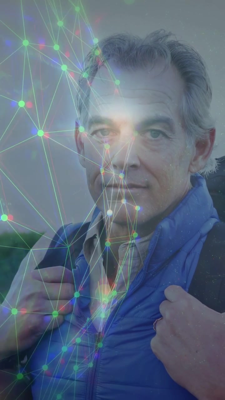 Video verticale: Uomo maturo che tiene delle cinghie, rivolto verso l'obiettivo, mentre una rete AR illumina il suo viso per la tecnologia.