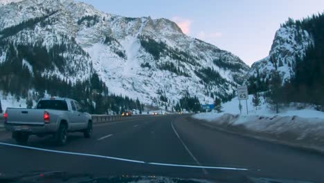 dashcam footage of driving through colorado snowy canyon with giant mountain ahead and traffic passing by
