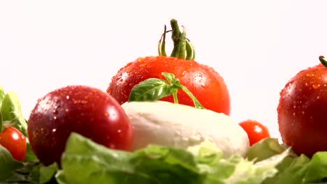 tomates y mozzarella en una hoja de lechuga giratoria, bucle
