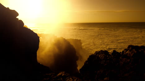 sunset over a rocky coast with powerful waves