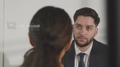 candidato masculino siendo entrevistado en el cargo por una entrevistadora vista a través de la ventana 8