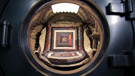 exploring the transition from a secure vault to an intriguing space: a journey from the outer mechanism to an artistic quilted interior