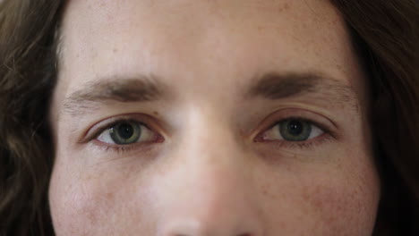 close up of man blue eyes opening caucasian male awake looking at camera watching iris focus face freckles