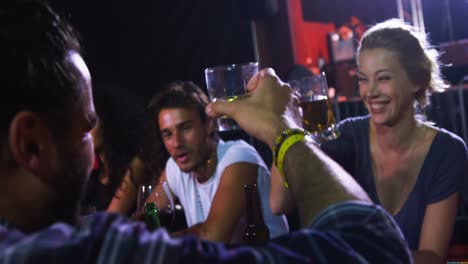 couple toasting glasses of beer at a concert 4k