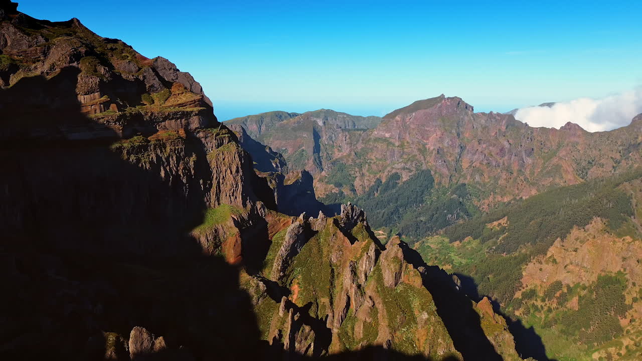 Spectacular mountains with sharp peaks. Sun lighting the slopes of the rocks. Azure sky at backdrop.