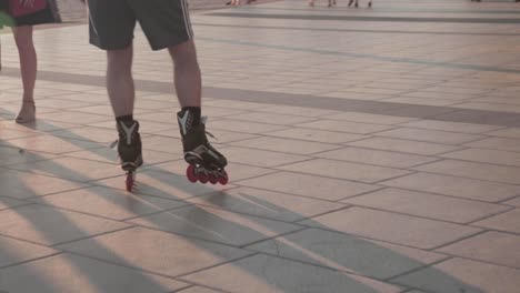 Slow-mo,-person-rollerblading-on-beach-boardwalk-during-golden-hour-between-crowd