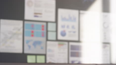 businessmen shaking hands behind glass office wall
