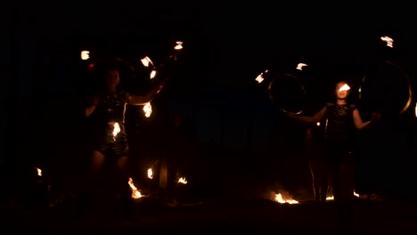 group of fire jugglers. people spit fire in a dark night outdoors performance.