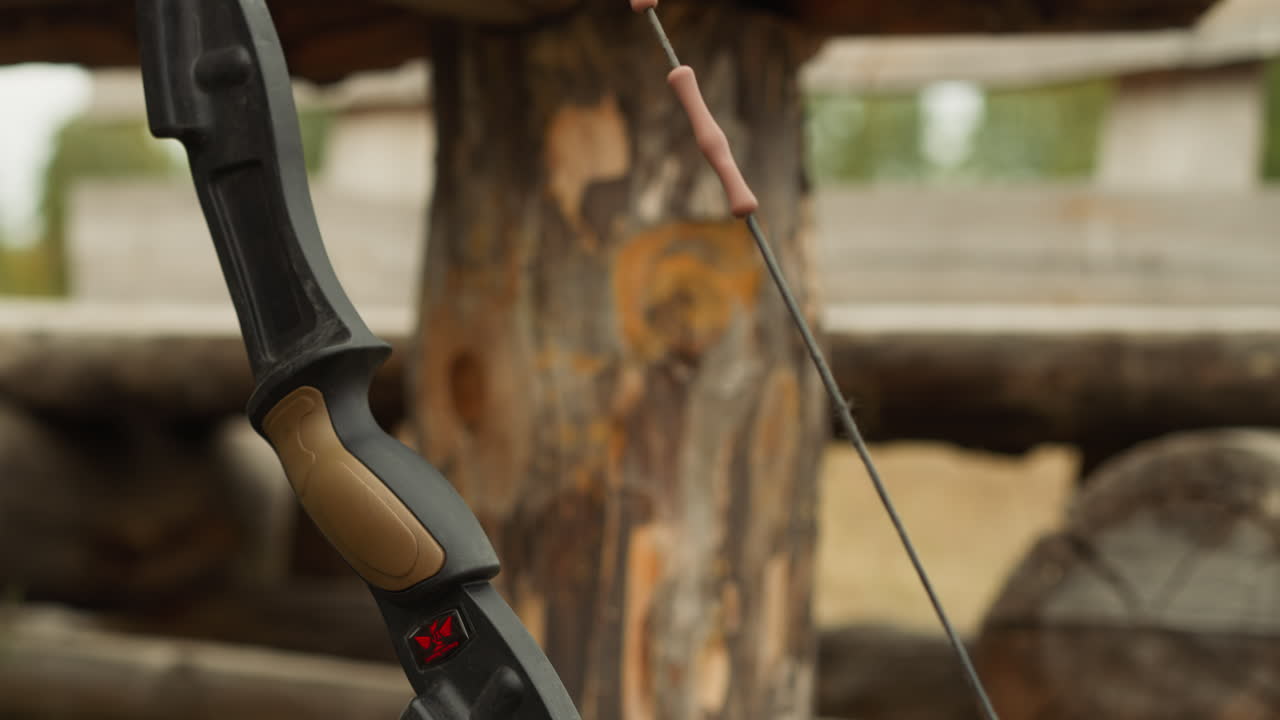 el arco vintage descansa sobre troncos cerca de una casa de madera de la edad media