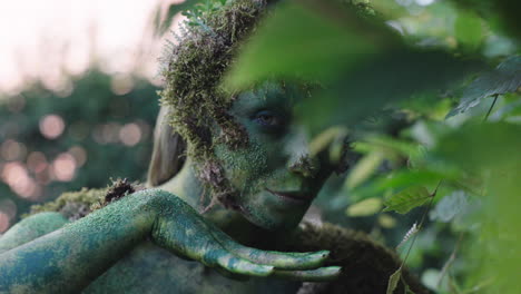 female bodypaint model gazing and smirking through the thick greenleaves - close up