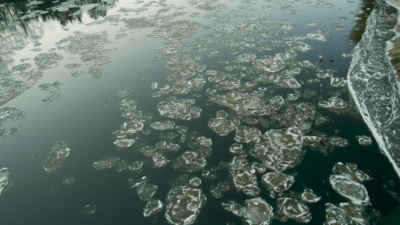 맑은 겨울날 강을 따라 천천히 내려가는 얼음 덩어리