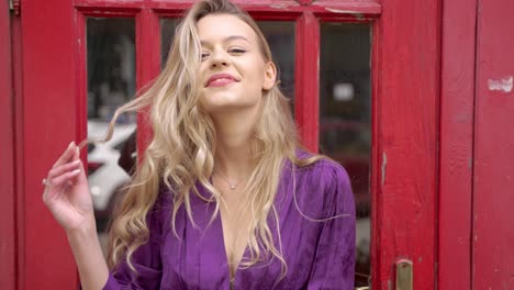 woman in purple dress by red door