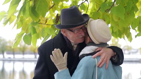 an elderly couple shares a loving embrace outdoors in autumn