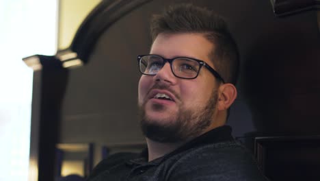 Close-up-on-a-man-looking-over-to-talk-to-his-friends-while-he's-playing-video-games