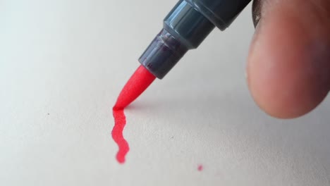 close-up of a hand drawing a red line with a marker