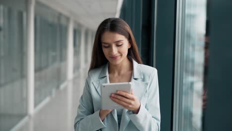 primer plano retrato de una mujer elegante en un traje azul con una tableta