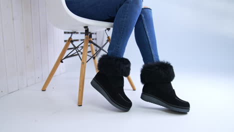 woman in jeans wearing black fur-trimmed winter boots