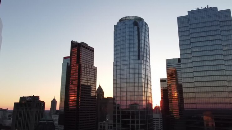 Uno splendido tramonto su uno skyline urbano moderno con riflessi su torri di vetro, che cattura la bellezza dell'architettura di una città contro il cielo che si oscura