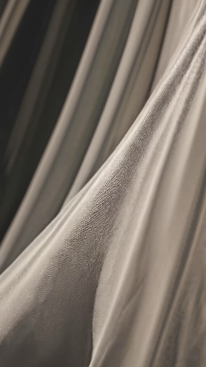 Close-up video shot of flowing fabric, capturing soft textures and gentle folds
