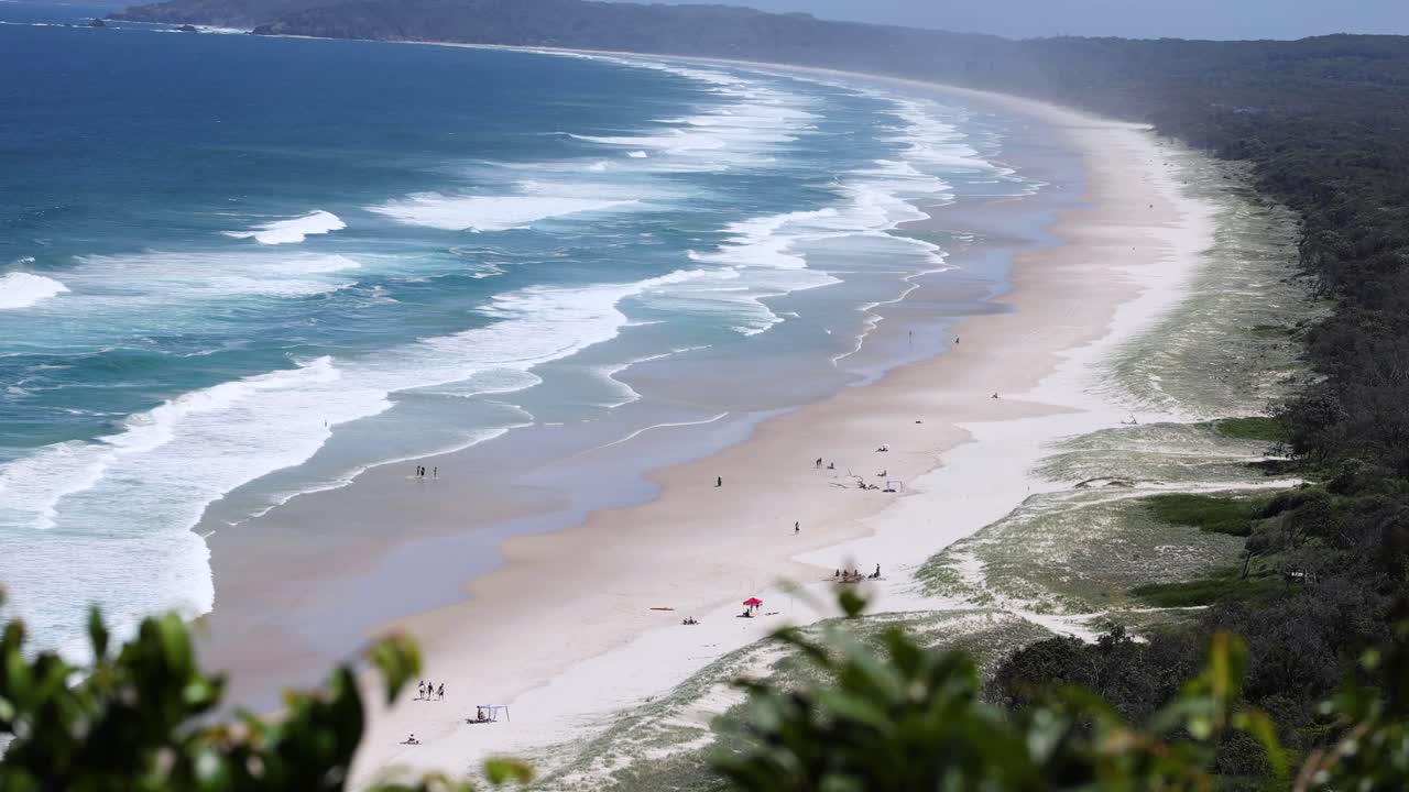 una escena de playa tranquila con olas y visitantes