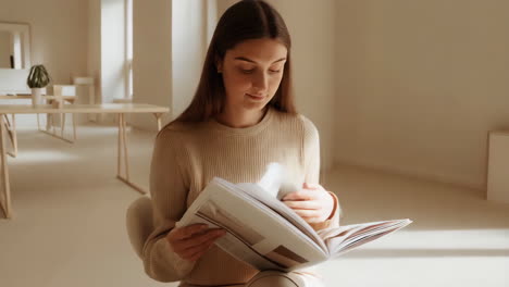 young woman reading a magazine indoors