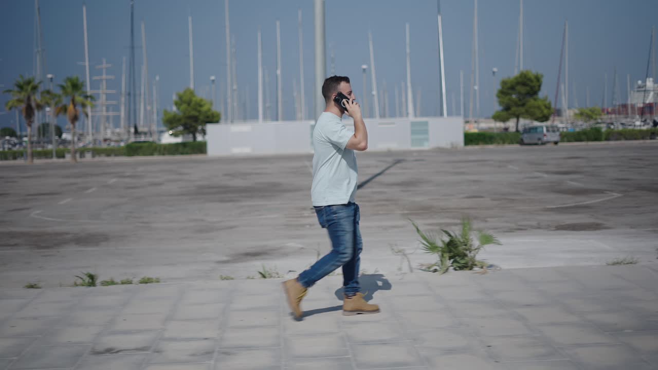 Man Walking and Talking on Phone in a Harbor City