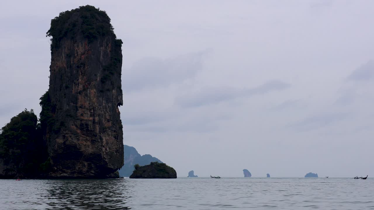 카야크 타는 사람 들 이 태국 크라비 의 멋진 절벽 을 탐험 하고 있다