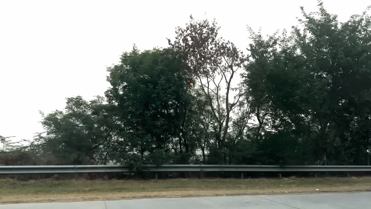 POV From Moving Car Driving Through The Highway Along The Trees In New Delhi, India.