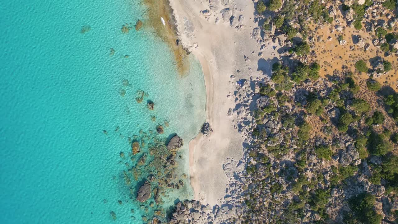Stunning aerial top-down view of Kedrodasos Beach in Crete, showcasing its crystal-clear waters, golden sand, and untouched natural beauty under the bright Mediterranean sun