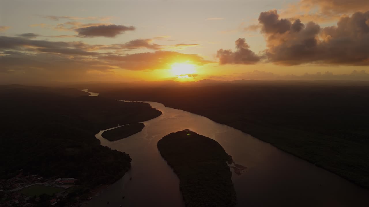 Peaceful golden sunset reflected in the Rio de Contas, Itacaré, Bahia, Brazil. Drone aerial, establishing static view