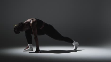 full length studio shot of woman wearing gym fitness clothing doing stretching exercise