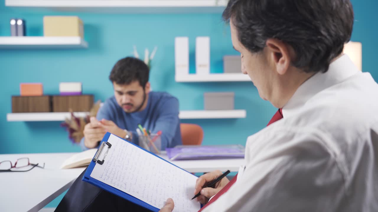 terapeuta, psicólogo hombre escucha a su joven paciente deprimido y le da noticias que lo harán feliz.