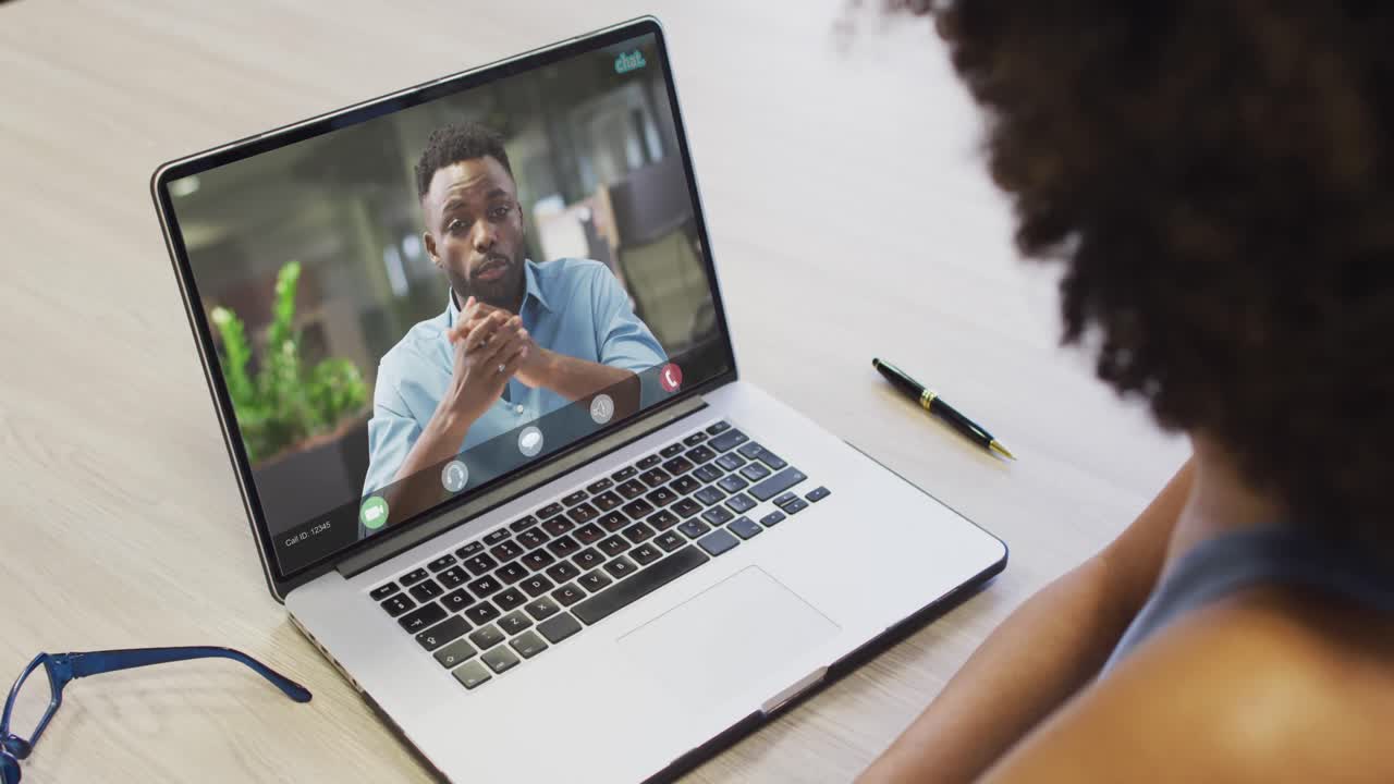 African american businesswoman using laptop for video call with african american business colleague
