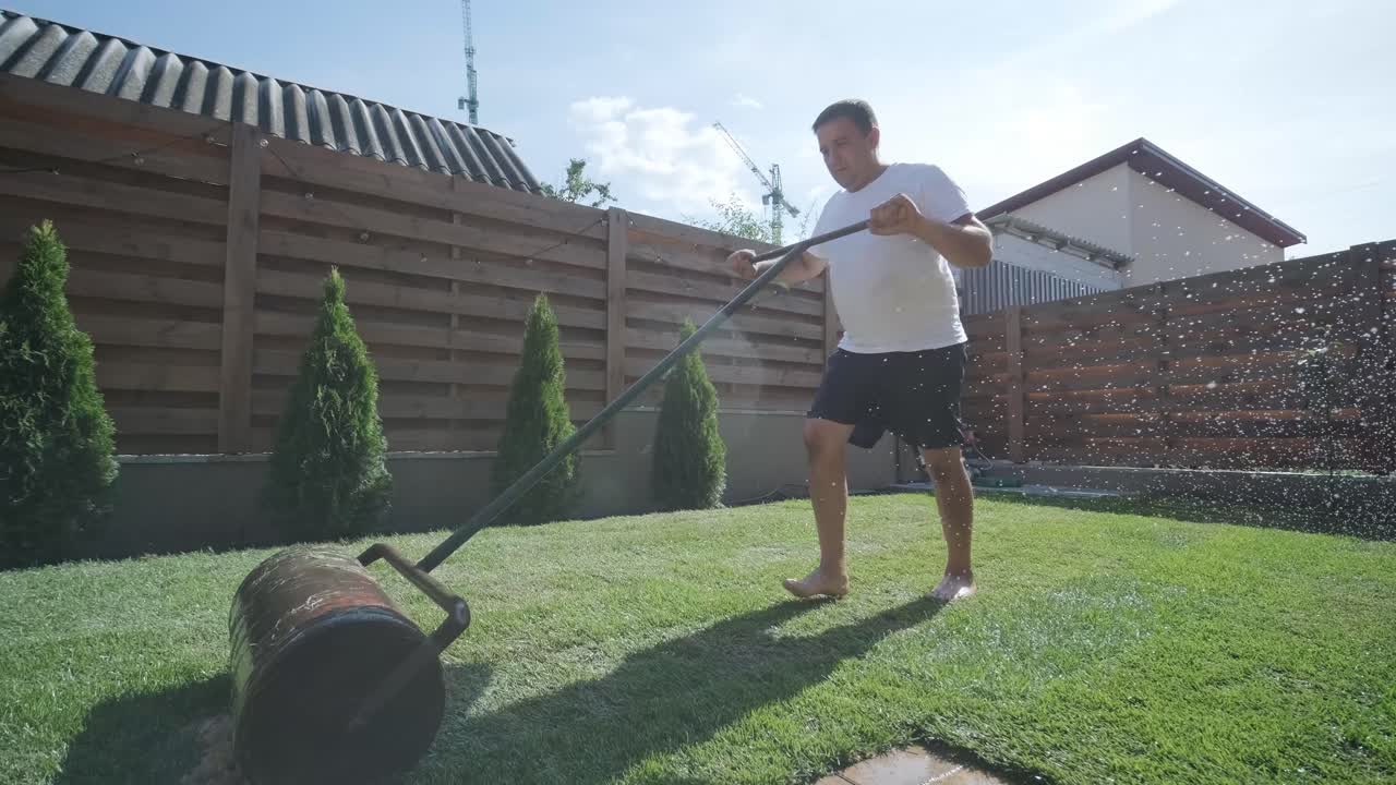 hombre colocando césped en el jardín del patio trasero para la instalación de césped y proyecto de jardinería, centrado en la mejora del hogar y el mantenimiento al aire libre para un césped fresco y verde en un patio residencial