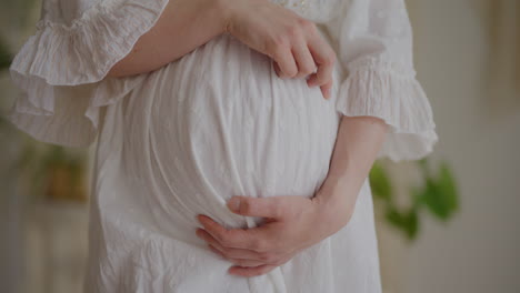 pregnant woman touching belly in expectation