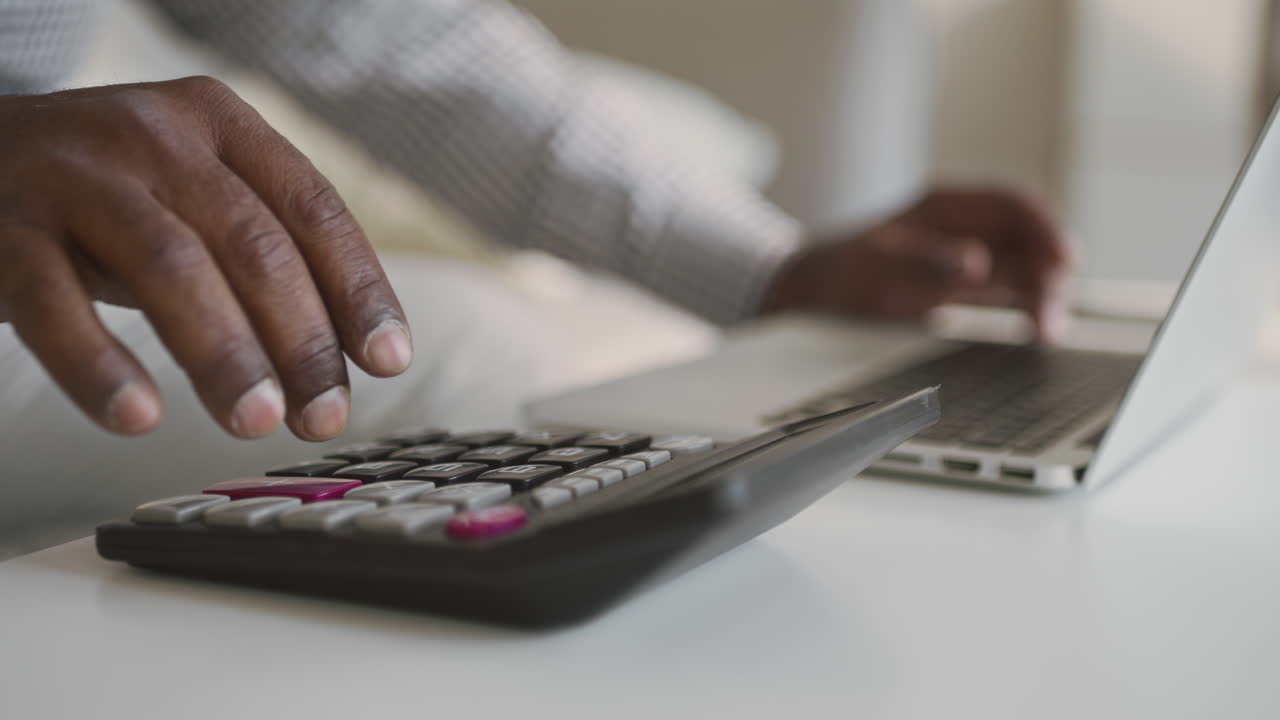 Person working on a laptop and calculator
