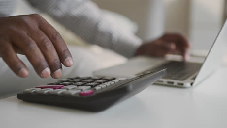 person working on a laptop and calculator