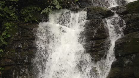 cerca de una poderosa cascada que cae sobre rocas en la selva tropical, costa rica