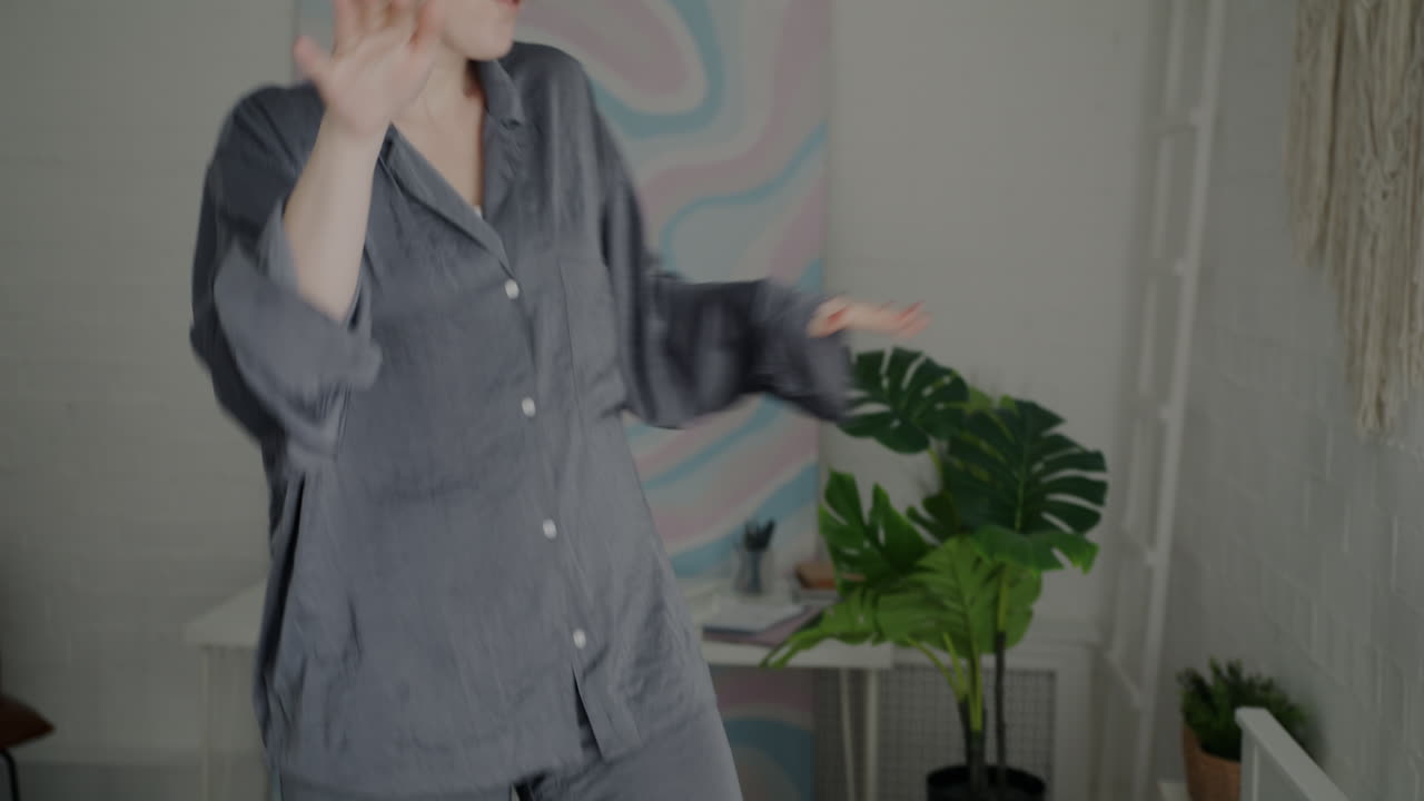 Woman in pajamas dancing in a bedroom
