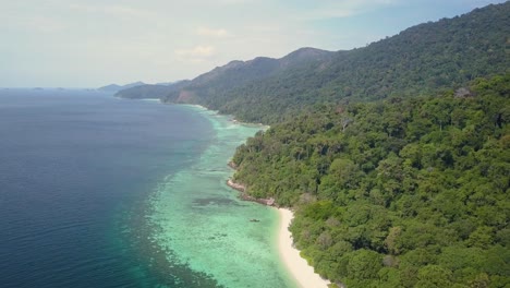 Vista-Aérea-De-Una-Isla-Exuberante-Con-Playa-De-Arena-Y-Aguas-Cristalinas-En-Tailandia---Seguimiento-De-Cámara-Y-Pedestal-Abajo