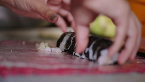 chef prepares sushi rolls, close up of hands and sliced sushi