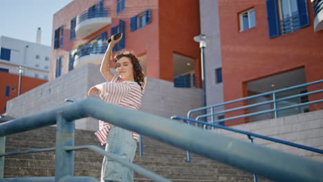 chica urbana escuchando música rítmica en auriculares en la escalera. mujer bailando