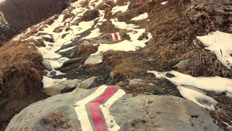 austrian hiking trails with white and red sign as direction guide printed on a stone