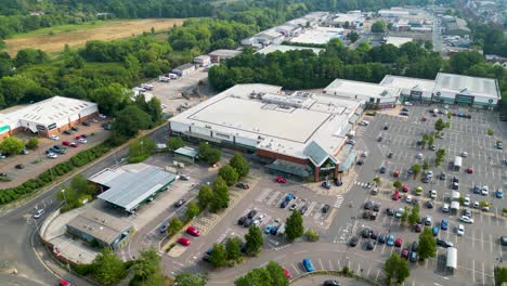 aerial footage of a retail district, with trees and fields in the background