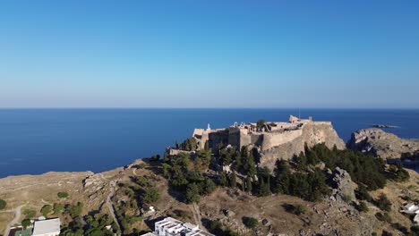 Akropolis-Von-Lindos-In-Rhodos,-Griechenland-Mit-Häusern-Und-Mittelmeer-Während-Des-Tages,-Gefilmt-Mit-Der-Drohne