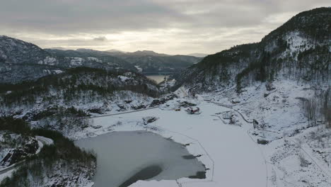 Snowy-alpine-landscape,-freezing-cold-winter-conditions;-aerial