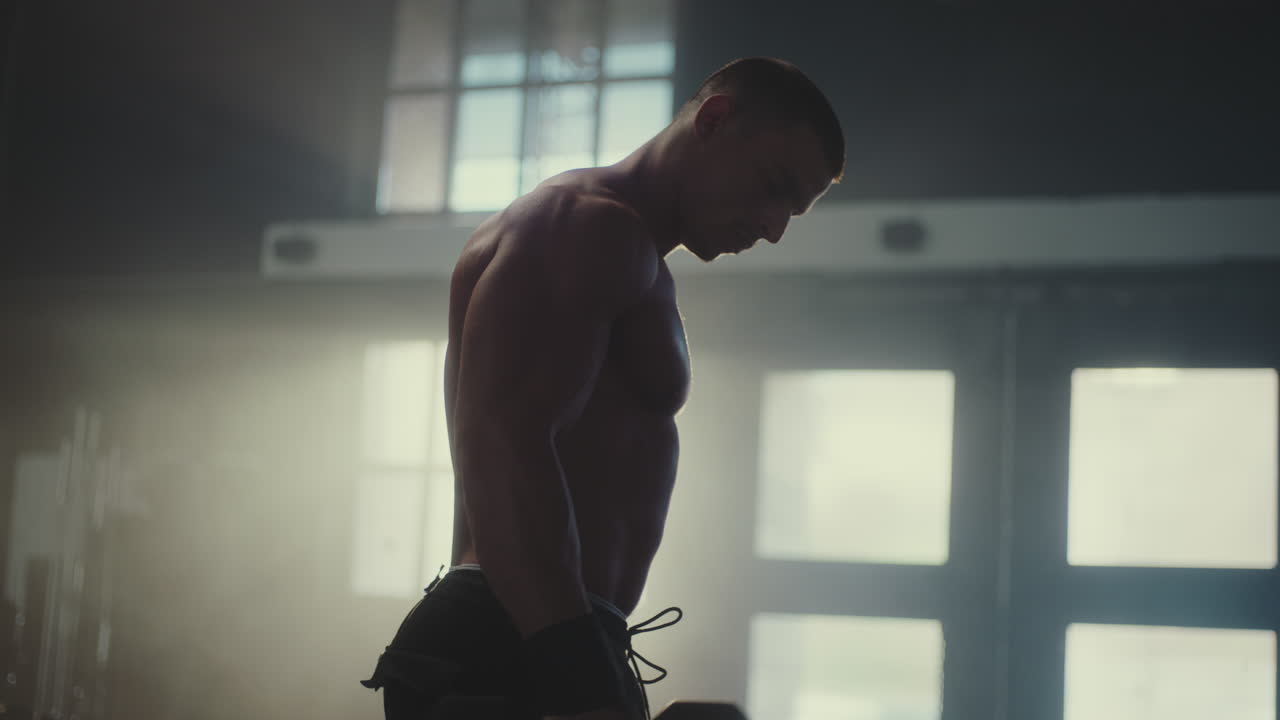 체육관 에서 덤벨 을 사용 하여 운동 하는 사람