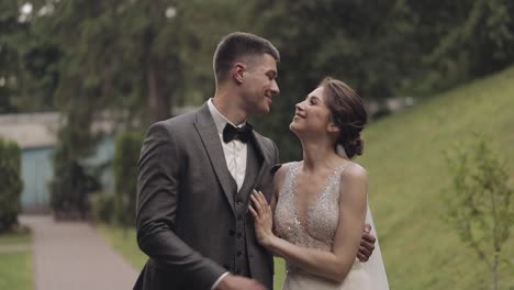 Lovely-newlyweds-caucasian-bride-groom-walking-in-park,-holding-hands,-wedding-couple-family