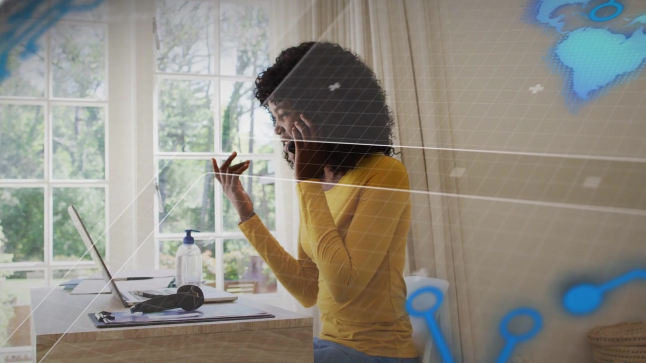 Woman taking work call working remote typing laptop grabbing bottle with blue nodes sweeping desk